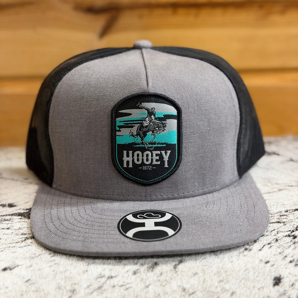 Front side view of black, grey, and teal hat. 