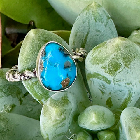 Turquoise stone ring in silver setting on green stones