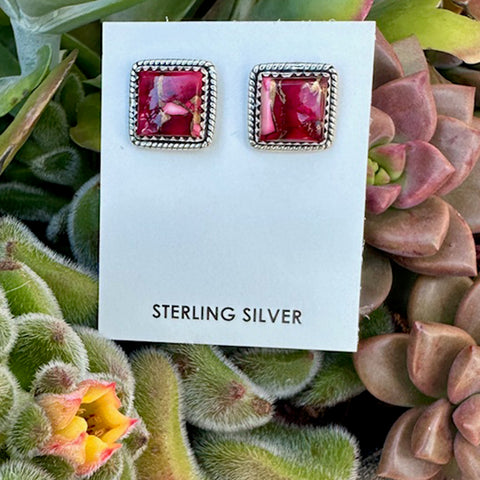 Pair of sterling silver dhalia Rose square stud earrings on a card, surrounded by succulents.
