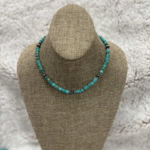 Beaded necklace of turquoise stones and Navajo pearls sitting on mannequin 