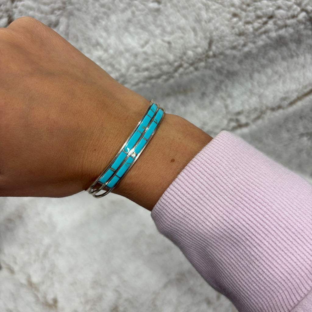 Sterling silver bracelet that has two rows of flat rectangular Kingman turquoise stones