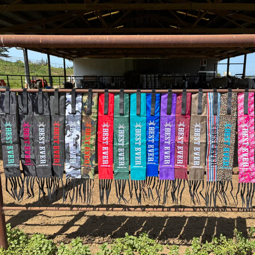 Line of assorted tail bags hanging on fence. 