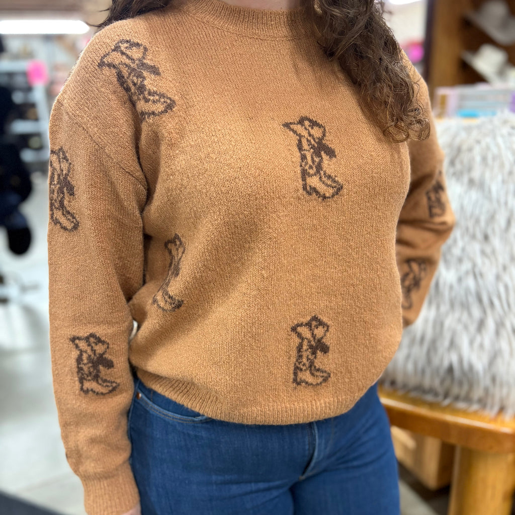 Light brown sweater with dark brown cowboy boot and cowboy has designs 