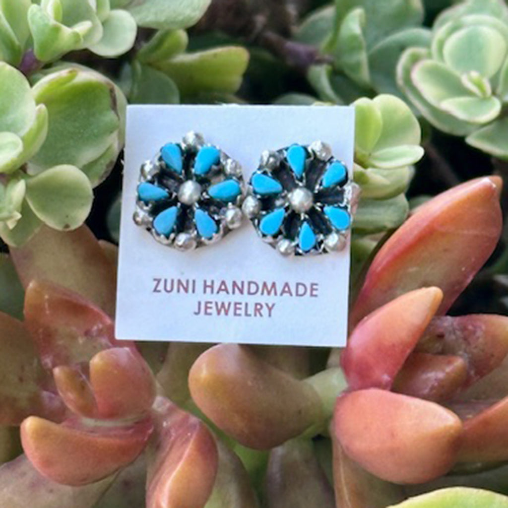 Zuni handmade turquoise cluster/flower style earrings on a card with succulent plants in the background