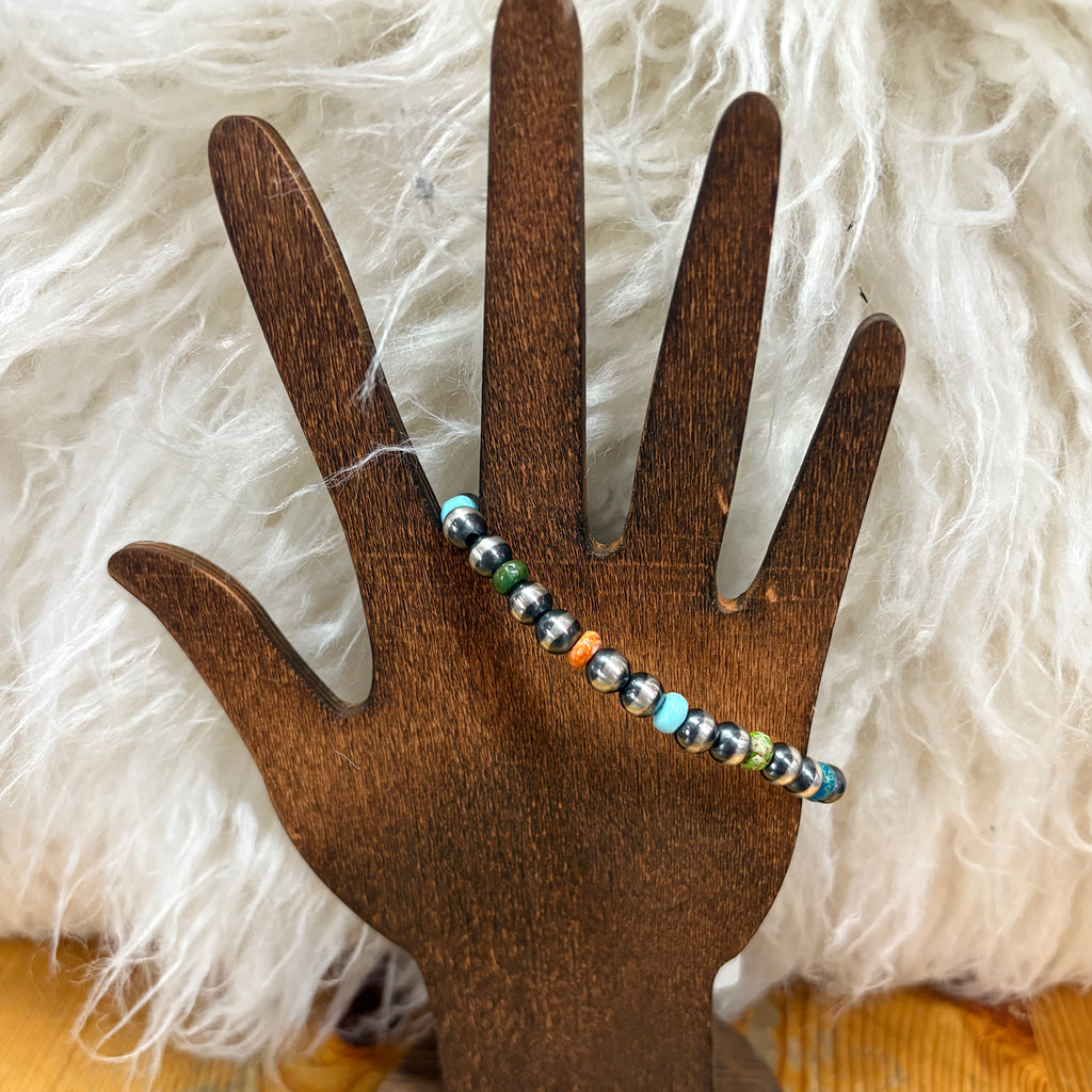 WOODEN HAND MODEL HOLDING THE MULTI STONE BRACELET 