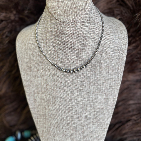 14 in necklace with graduated Navajo pearls that range from 3-9mm with the biggest pearl in the middle.