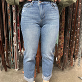 Front view of jeans, light blue with rolled cuff. Small distressed details under left pocket.