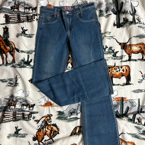 Flat lay view of the jeans, medium wash with Cowgirl Hardware logo on left pocket.