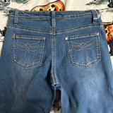 Close up view of the back pockets, boot stitch design has silver and gold stitching.