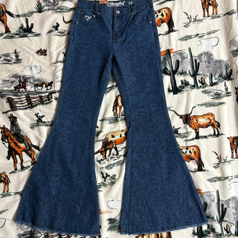 Flat lay picture of dark blue jeans with black floral/tool design and flare bottoms.