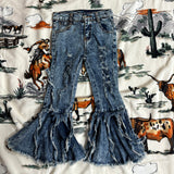Flat lay picture of the front of the jeans, light and dark blue color with distressed details on the front of the legs and bell bottoms with strings falling down.
