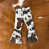 Flat lay picture of the front of the jeans, white jeans with black and brown cow spot patterns in a bell bottom style.