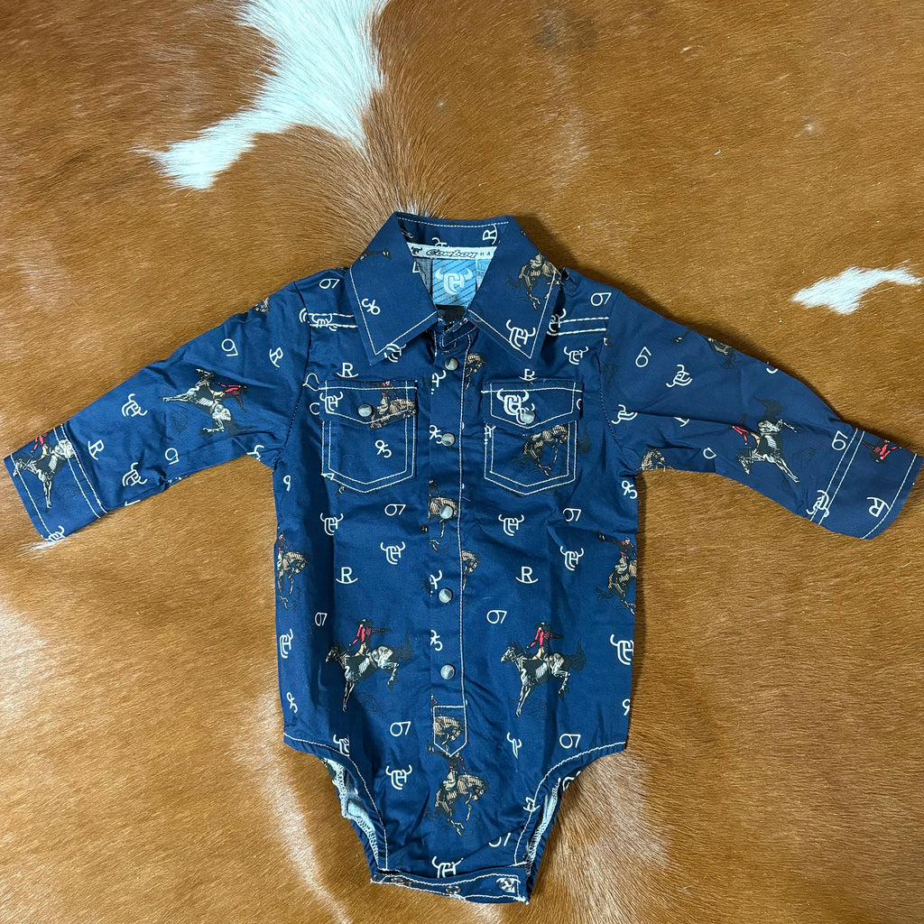 Flat lay view of a long sleeve navy onesie with retro bronc designs and white brand designs. Onesie has two front pockets and pearl snap closures. 