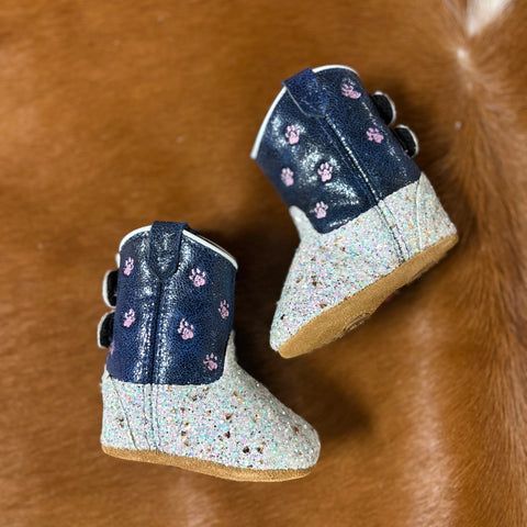 Side angle of the boots, top is dark blue with pink bear paws and bottoms are white glitter.