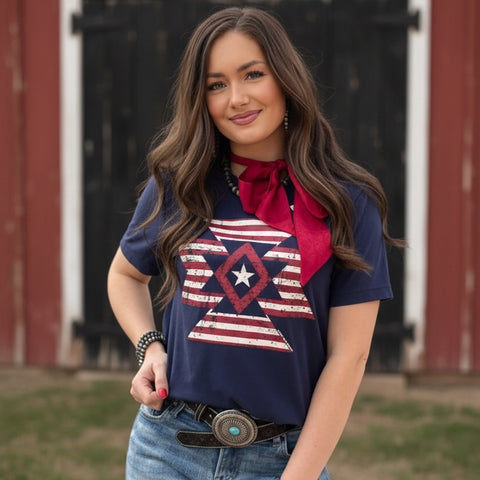 Model Wearing Navy Freedom Aztec Tee Standing in Front of a Barn