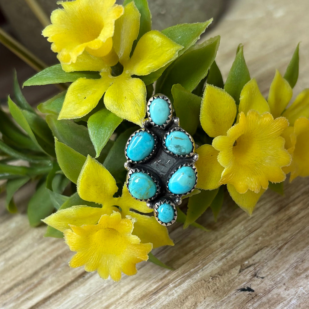 Adjustable cluster ring with six Kingman turquoise stones in the shape of a diamond.