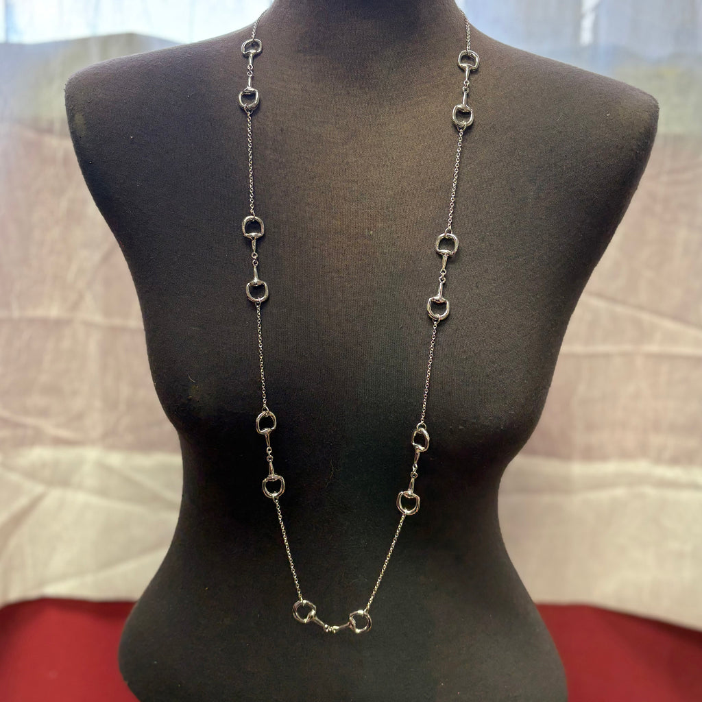 Long silver necklace with seven horse bits.
