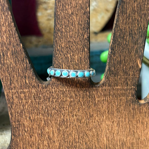 Silver band ring with turquoise colored dots all the way around. 