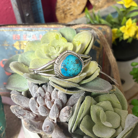 Sterling silver cuff with large turquoise stone in the middle. 