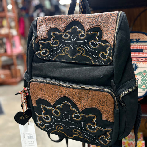 Black suede backpack with brown tooled leather accents, gold and white boot stitch designs, and 4 zipper pockets.