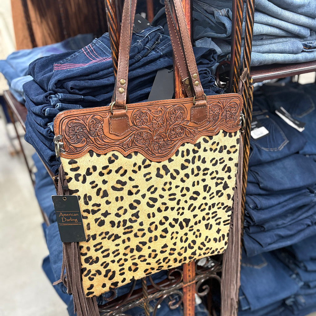 Cheetah print shoulder bag with tooled leather on the top and fringe on the sides. 