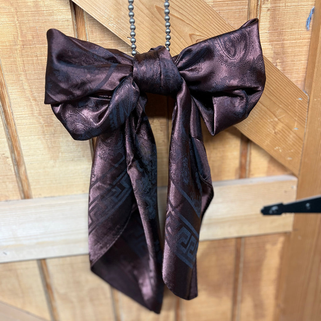 Dark brown jacquard wild rag styled in a bow 