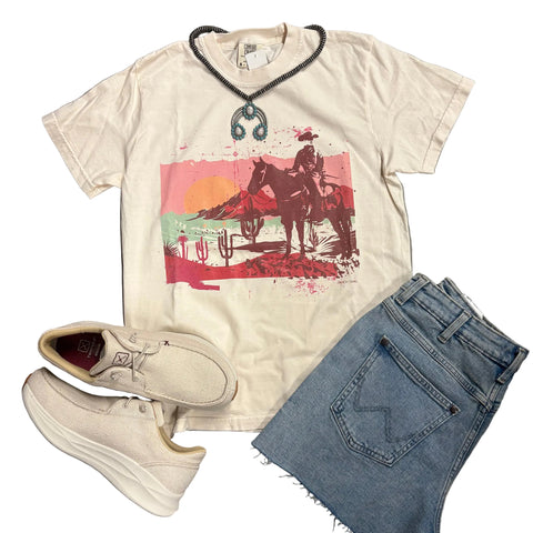 Flay lay of cowboy state t-shirt with necklace, shoes, and shorts laying on and next to it. 