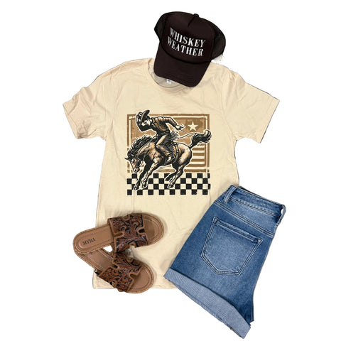 Flay lay of cream checkered bronc t-shirt with a hat, sandals, and shorts laying around it. 