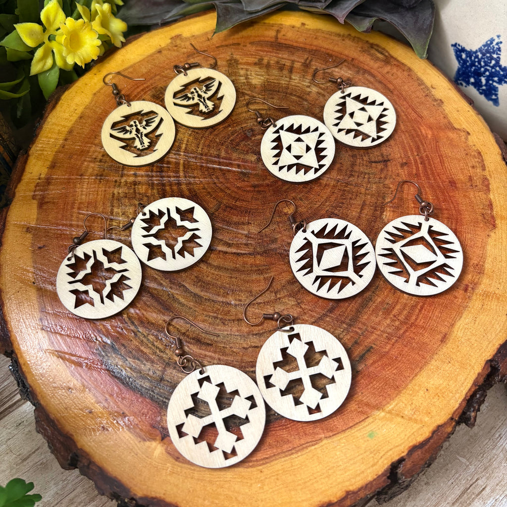 Assorted wooden earrings displayed on wooden block. 