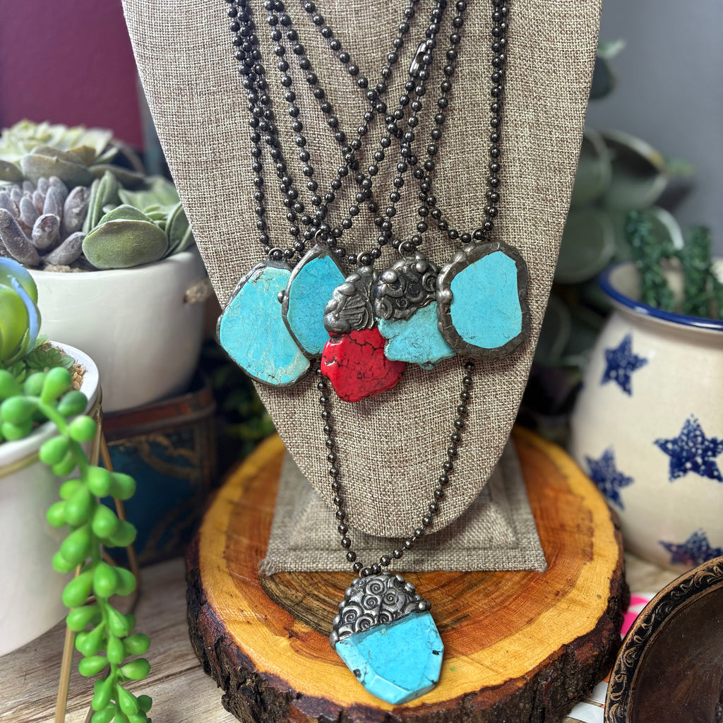 Assorted raw stone necklaces on jewelry stand with the red one in the middle. 