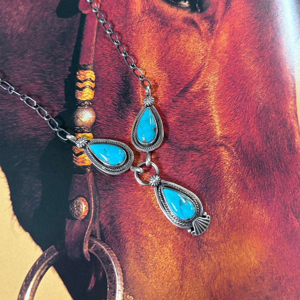 "Kiera" Necklace laying on background with a horse. 