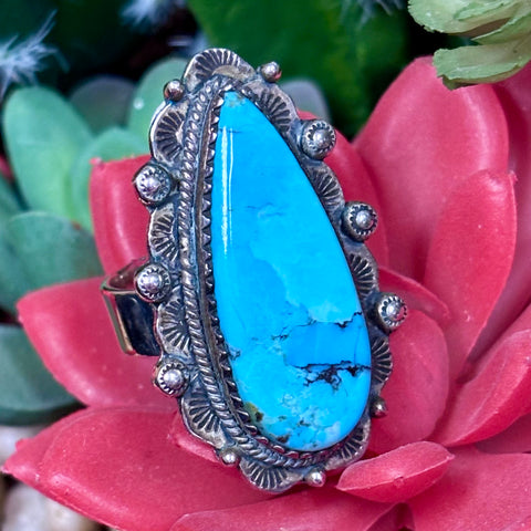 Close up view of a Kingman turquoise oblong teardrop adjustable ring