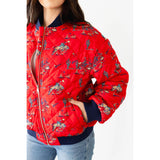 Model wearing the Red Quilted Cowboy Bomber Jacket from a side angle with one hand in the pocket, highlighting the quilted texture and bold red color.