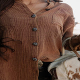 Close-up of the Saddle Acres Button Up showing the matching dark buttons and subtly textured fabric.