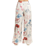 Back view of wide-leg cream  pants with cowboy-themed print