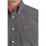 Close‑up of the Cinch Men’s Black Multi Geo Print Shirt on the model, showing the fine geo pattern, button‑down collar, and embroidered chest logo.

