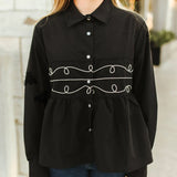 Close up picture of the front of the shirt, black collar at the neckline.