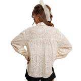 Back view of a woman wearing an off white colored lonlg sleeve lace blouse