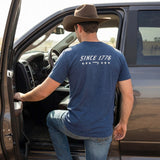 Model wearing the Lazy J Ranch Navy Blue Liberty T‑shirt, back view showing the Since 1776 Graphic