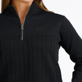 Close-up of woman wearing a black quarter-zip pullover with a textured cable-knit front, stand collar, side pockets, and subtle CINCH logo.