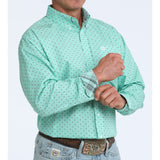 Man wearing turquoise grey diamond print long sleeve shirt with turquoise flannel print sleeve.