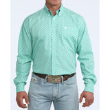 Man wearing turquoise long sleeve shirt with grey diamond pattern.
