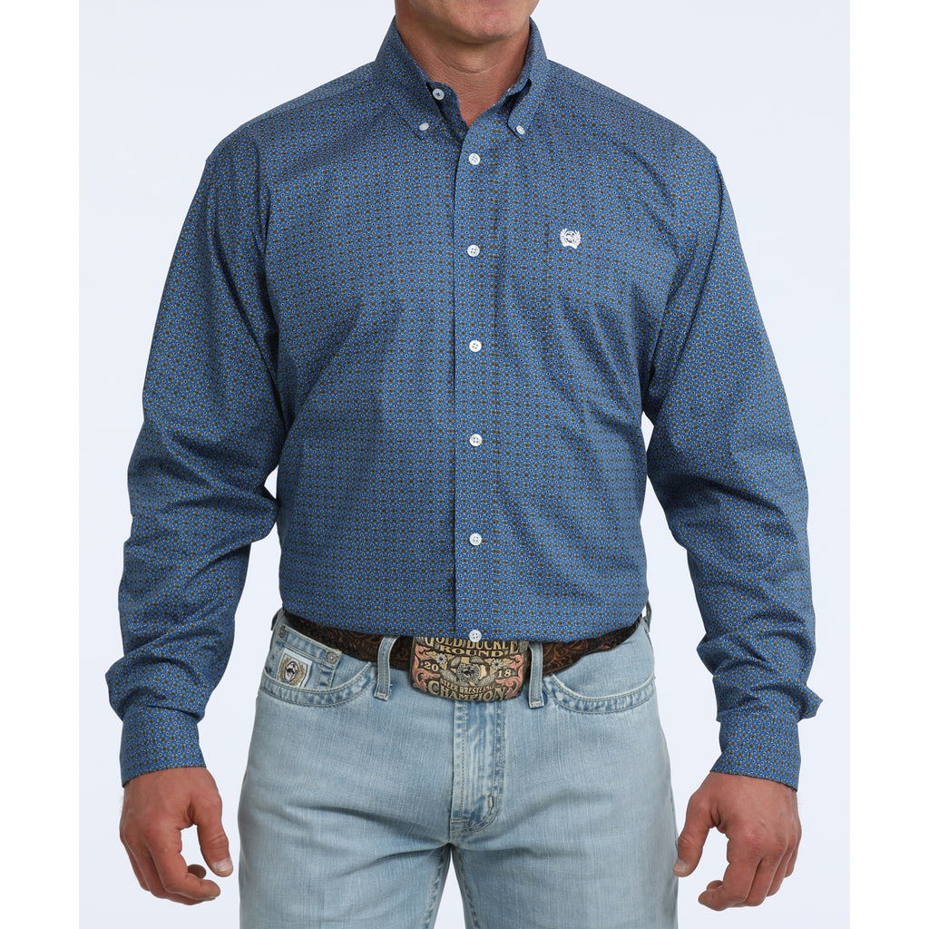 Front view of man wearing blue long sleeve shirt with geometric print in front of white background.