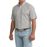 Side view of model in Cinch Men’s Grey and White Geo Print Short Sleeve Shirt, highlighting sleeve detail, tailored silhouette, and geo print design.