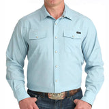 Light blue pearl snap long sleeve shirt with two chest pockets and a spread collar. 
