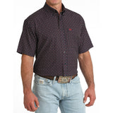 Angled view of model in the Cinch Navy Geo Print Short Sleeve Shirt highlighting the sleeve length, tailored silhouette, and detailed geo print.