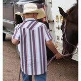 Back view of model in kids’ western striped pearl snap shirt leading horse, highlighting shirt stripes and western yoke detail.
