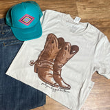 Tan tee with brown boots with spurs on the front. saying under boot picture says " put your big girl boots on " 