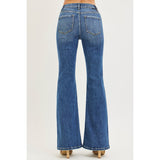 Back view of a model wearing Risen dark tummy control high rise flare jeans, showing the lifted fit, clean back pockets, and smooth flare leg.