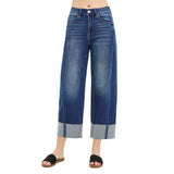 Model wearing dark slouchy barrel crop cuffed jeans, front view showing the relaxed high‑rise fit, cropped barrel leg, and clean dark‑wash finish.